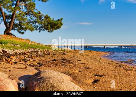 Illa de Arousa Strand mit der Brücke im Hintergrund an einem sonnigen Sommertag. Stockfoto