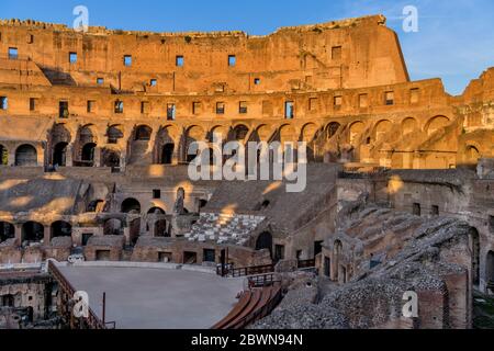 Innenraum des Kolosseums - BLICK auf den Sonnenuntergang über der Arena und den alten hohen Mauern im Inneren des Kolosseums. Rom, Italien.