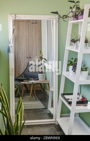 Interieur des gemütlichen Balkon mit grünen Wänden, Sitzecke mit Teppich, Sessel und zwei Couchtische Stockfoto