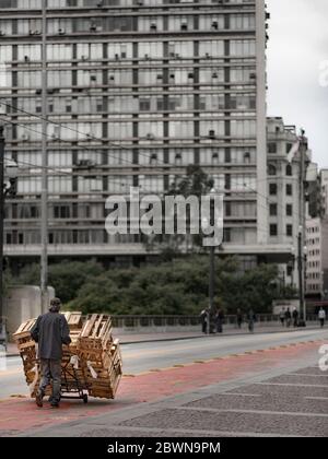 Ein Arbeiter, der einen Haufen Holzkiste trägt Stockfoto