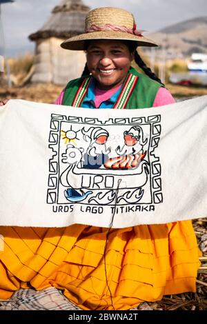 Die Uros-Gemeinschaft zeigt ihr Handwerk, während Touristen ihre schwimmende Insel aus Totorareed am Titicaca-See in Peru besuchen. Stockfoto