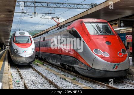 Hochgeschwindigkeitszüge - EIN silberner Frecciargento ETR 600 von Trenitalia, der am Bahnsteig ankommt, neben einem geparkten roten Frecciaros ETR 500, in Rom Termini. Stockfoto