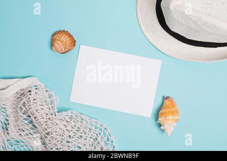 Sommer-Accessoires, Muscheln und leere Papierkarte auf blauem Hintergrund Stockfoto