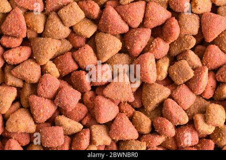 Brown Dry Dog Futter Stapel Hintergrund Nahaufnahme. Stockfoto