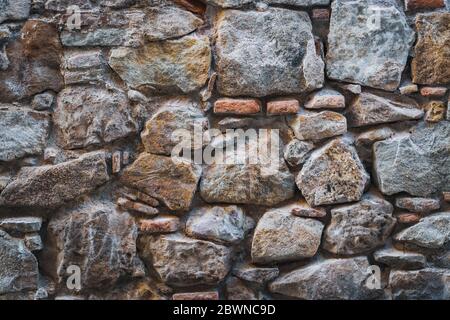 Textur einer alten Mauer aus Natursteinen und roten Ziegeln Stockfoto