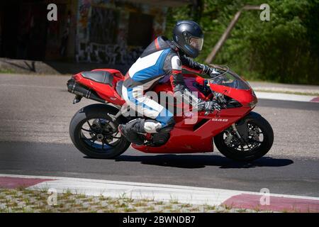 25-05-2020 Riga, Lettland. Motorradfahrer fährt auf Straße, Seitenansicht, Nahaufnahme. Stockfoto