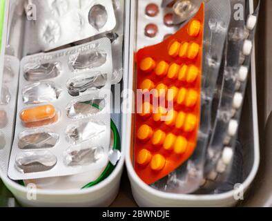 Viele Medikamente, Pillen und Tabletten in vielen geöffneten Blisterpackungen chaotisch in einer Box gestapelt, medizinische Versorgung zu Hause. Vitamine und Nahrungsergänzungsmittel Stockfoto