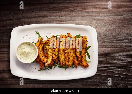 Direkt über Schuss schwarzer Sesamcod Goujons mit Tartare-Sauce in einem Teller serviert Stockfoto