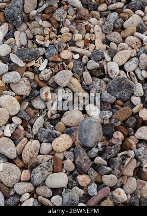 Verschiedene Struktur am Strand - Wasser und Sand, Steine und Kiesel, Wellen und Spritzer. Selektiver Fokus. Stockfoto