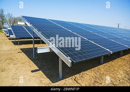 Feld mit solarthermischen Kollektoren, die Paneele erzeugen erneuerbare Energie durch Photovoltaik-Technologie, blauer Himmel mit Kopierraum, ausgewählter Fokus, schmal Stockfoto