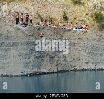 Shadwell Quarry, Love Wenlock, Shropshire. Juni 2020. Hunderte von jungen Menschen und ihre Familien, die während der Pandemie in der „Blauen Lagune“, einem stillgelegten Kalksteinbruch in der Nähe von Much Wenlock, baden und schwimmen. Die Polizei hat eine Sicherheitswarnung ausgegeben, nachdem zwei Menschen letzte Woche aus dem stillgelegten Shropshire-Steinbruch gerettet wurden, aber sie waren noch heute in Schwärme. Stockfoto