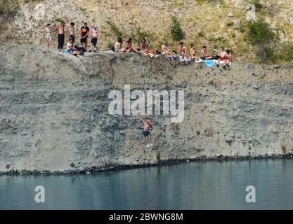 Shadwell Quarry, Love Wenlock, Shropshire. Juni 2020. Hunderte von jungen Menschen und ihre Familien, die während der Pandemie in der „Blauen Lagune“, einem stillgelegten Kalksteinbruch in der Nähe von Much Wenlock, baden und schwimmen. Die Polizei hat eine Sicherheitswarnung ausgegeben, nachdem zwei Menschen letzte Woche aus dem stillgelegten Shropshire-Steinbruch gerettet wurden, aber sie waren noch heute in Schwärme. Stockfoto