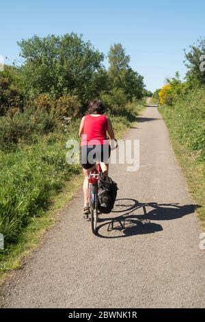 Reife Frau, die entlang der Küste entlang radelt, um Küste Radweg C2C zwischen Sunderland und Consett, England, Großbritannien Stockfoto