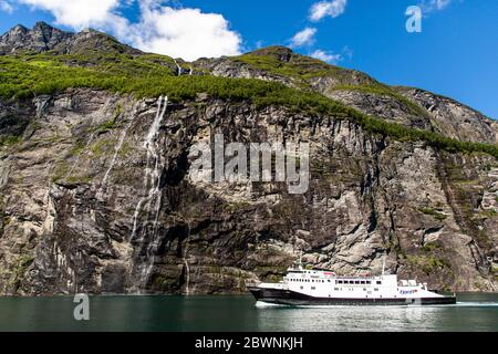 Geiranger, Geirangerfjord, Norwegen - Juni 2019: Touristisches Schiff Beerenboot schwimmende Linienschiff in der Nähe Geiranger im Geirangerfjord im Sommer Tag. Stockfoto