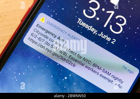 Elektronische Benachrichtigung der Behörden von New York City, die vom 2. Bis 7. Juni 2020 um 20:00 Uhr eine Ausgangssperre für die gesamte Stadt ankündigen, die auf einem Telefon in NYC, NY, USA angezeigt wird. Stockfoto