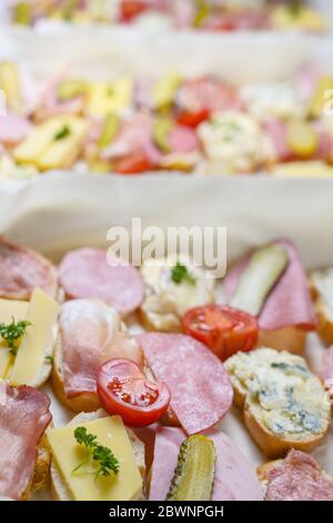 Viele Baguette-Kanapees mit Käse und Wurst, Tomaten und Gurken auf einem zwanglosen Party-Buffet, Kopierraum, ausgewählter Fokus, enge Schärfentiefe Stockfoto