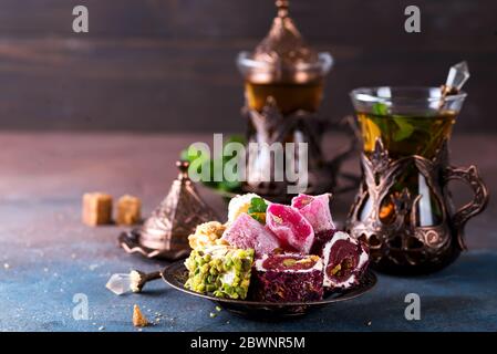 Traditionelle türkische Süßigkeiten mit Tee Minze in einem traditionellen Glas auf einem Betongrund Stockfoto
