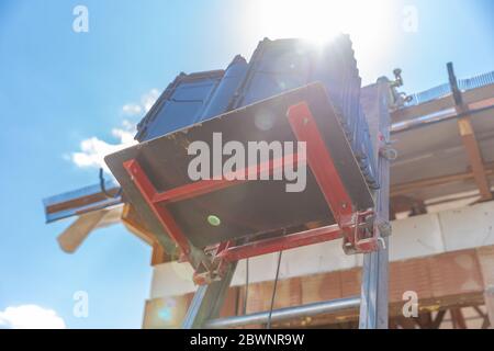 Dachziegel auf einem Aufzug für den Transport zum Dach während der Verlegung Stockfoto