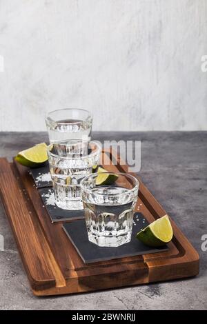 Tequila Schüsse, Limetten, Salz auf Holzbrett Stockfoto