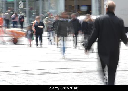 Menschen in der Fußgängerzone Einkaufszone, Bewegung verschwimmen durch langfristige Exposition, gefährliche Stadt Leben Konzept während Coronavirus Pandemie, Kopieraum Stockfoto