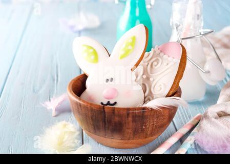 Bunte osterhasen Cookies in Bambus Schüssel auf blauem Holz Hintergrund Stockfoto