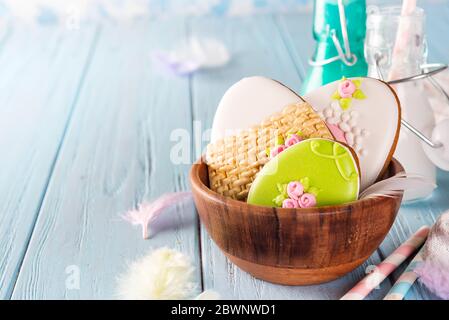 Bunte osterhasen Cookies in Bambus Schüssel auf blauem Holz Hintergrund Stockfoto