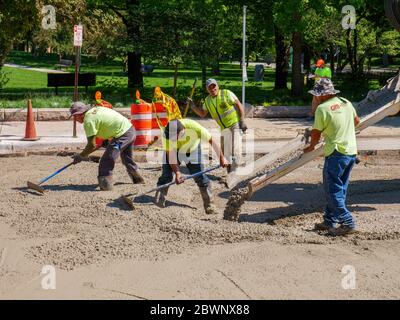 Oak Park, Illinois, USA. Juni 2020. Straßenbauarbeiter gießen Beton während des Lake Street-Wiederaufbauprojekts an einem heißen frühen Junitag. Stockfoto