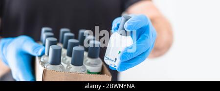 Handdesinfektionsmittel Hygiene Alkohol Gel Flaschen in den Händen des Mannes trägt Latex medizinische Handschuhe und Schutzmaske während Coronavirus COVID-19 Pandemien. Hea Stockfoto