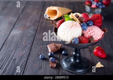 Set von Eis Kugeln in verschiedenen Farben und Geschmacksrichtungen mit Beeren, Schokolade auf dunklem Hintergrund Stockfoto