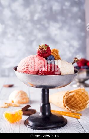 Set von Eis Kugeln in verschiedenen Farben und Geschmacksrichtungen mit Beeren, Schokolade auf Holzhintergrund Stockfoto