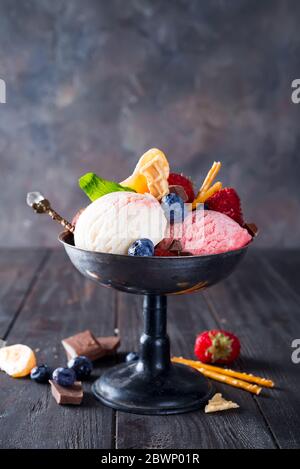Set von Eis Kugeln in verschiedenen Farben und Geschmacksrichtungen mit Beeren, Schokolade auf dunklem Hintergrund Stockfoto