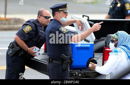 Hamden, CT, USA. Juni 2020. Polizeibeamte von Hamden, Connecticut, geben Wasser aus, nachdem sie mit Aktivisten aus New Haven, Connecticut, zum Polizeihauptsitz in Hamden, Connecticut, marschiert sind. Die Botschaft war Einheit und jeder, der sich als Individuen kennenlernen konnte. Ende des marsches applaudierten sich Aktivisten und Polizei. Kredit: Stan Godlewski/ZUMA Wire/Alamy Live News Stockfoto