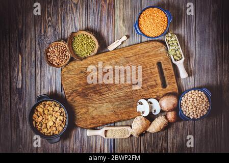 Sortiment aus Hülsenfrüchten, Linsen, Chikpea und Bohnen von oben. Zusammensetzung von verschiedenen Arten von Hülsenfrüchten in Schalen auf Holzhintergrund für eine gesunde Ernährung. Stockfoto