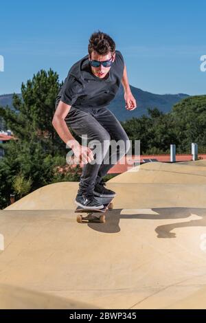 Skateboarder trainieren auf einem Pumptrack Park an einem sonnigen Sommertag. Stockfoto