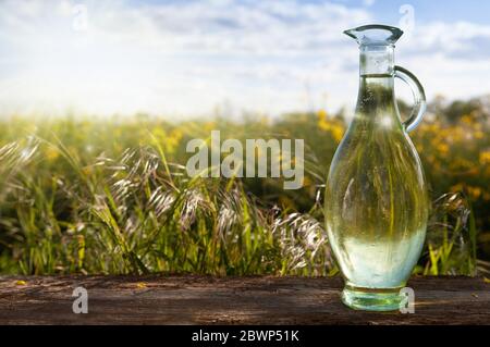 Platz für eine Inschrift - alternative Medizin. Eine Glasschale gegen ein grünes Feld, Blumen, Stockfoto