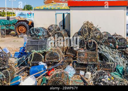 Alte, gut gebrauchte Hummer-Töpfe stapelten sich auf einem unordentlichen Haufen am Strand von Bognor Regis, einer Küstenstadt in West Sussex, Südküste Englands Stockfoto