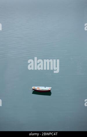 Treibend Verlassene Dinghy. Ein altes, verlassene Schlauchboot, das im Wasser liegt. Stockfoto