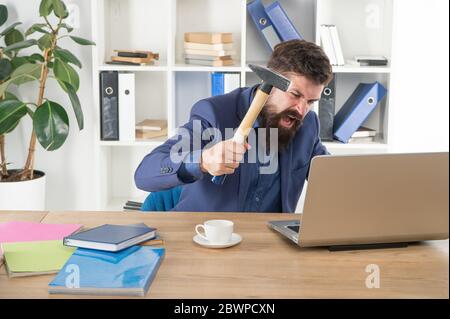 Hasserfüllter Job. Ungültiger Computer. Lästige Werbung und Pop-up-Banner. Langsame Internetverbindung. Veraltete Software. Computerverzögerung. Nachlagesystem. Hasse Büroalltag. Mann bärtigen Crush Computer. Laptop zerstören. Stockfoto