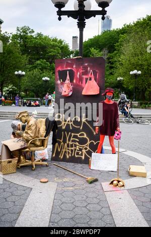 Eine menschliche Statue Straßenkünstler neben einem Schild mit der Aufschrift "Black Lives Matter" und eine Schaufensterpuppe in Union Square NYC am Marsch für George Floyd 6/2/2020 Stockfoto