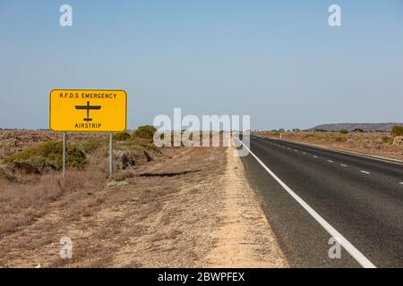 Das Schild des Royal Flying Doctor Emergency Service, das die Straße bezeichnet, kann auch als Landebahn in einem medizinischen Notfall verwendet werden. Gefangen in Westaustralien Stockfoto