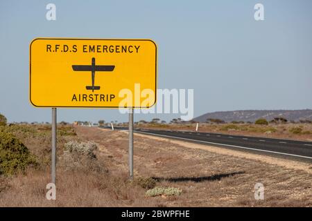 Das Schild des Royal Flying Doctor Emergency Service, das die Straße bezeichnet, kann auch als Landebahn in einem medizinischen Notfall verwendet werden. Gefangen in Westaustralien Stockfoto