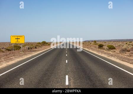 Das Schild des Royal Flying Doctor Emergency Service, das die Straße bezeichnet, kann auch als Landebahn in einem medizinischen Notfall verwendet werden. Gefangen in Westaustralien Stockfoto