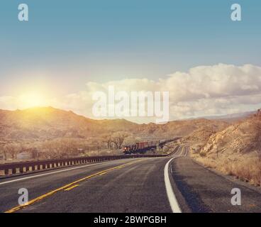 Güterzug auf der Strecke entlang einer Autobahn in Arizona, USA Stockfoto