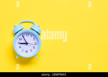 Blauer Wecker auf gelbem Hintergrund Stockfoto