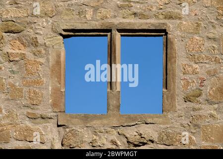 Braunes Fenster in einem Backsteinschloss, fotografiert im Vollformat, blauer Himmel, tiefe Perspektive. Deutschland. Stockfoto