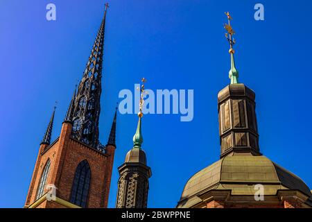 Verzierte Türme und Türme der mittelalterlichen Riddarholmen-Kirche, Grabkirche schwedischer Monarchen in Stockholm, Schweden, vor blauem Himmel Stockfoto