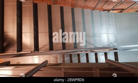 Rotes Ziegelgebäude mit einer modernen Treppe im Loft-Stil mit Metallgeländer. Treppen schmücken das Gebäude. Modernes Treppenhaus. Stahlgeländer. Treppe i Stockfoto