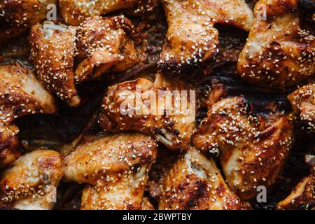Gebackene eingelegte Hähnchenflügel. Mit Sesamsamen bestreut. Kochen Huhn mit Gewürzen im Ofen Flat Lay. Nahaufnahme Stockfoto
