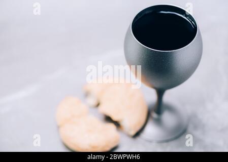 Gemeinschaft Stillleben. Ungesäuertes Brot, Kelch Wein auf grauem Hintergrund. Konzept der christlichen Kommunion zur Erinnerung an das Opfer Jesu. Ostern Stockfoto