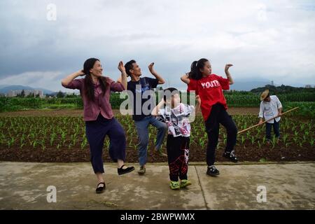 (200603) -- RUIAN, 3. Juni 2020 (Xinhua) -- Peng Xiaoying (1. L) und Fan Deduo genießen einen Tanz mit ihren Kindern auf einem Bauernfeld im Xia'Ao Dorf der Gemeinde Mayu, Ruian, Ostchinesische Provinz Zhejiang, 1. Juni 2020. Wenn sie mit der Arbeit auf dem Bauernhof fertig sind, haben Fan Deduo und seine Frau Peng Xiaoying ein großes Hobby - Tänze choreographieren und ausprobieren. Vor achtzehn Jahren wurde Fan bei einem Verkehrsunfall verletzt und das Trauma führte ihn zu einer Depression. 2016 hatte er sich entschieden, mit Depressionen fertig zu werden, indem er das Tanzen mit Peng lernte. Das Paar betreibt nun einen Abend-Livestream-Chann Stockfoto